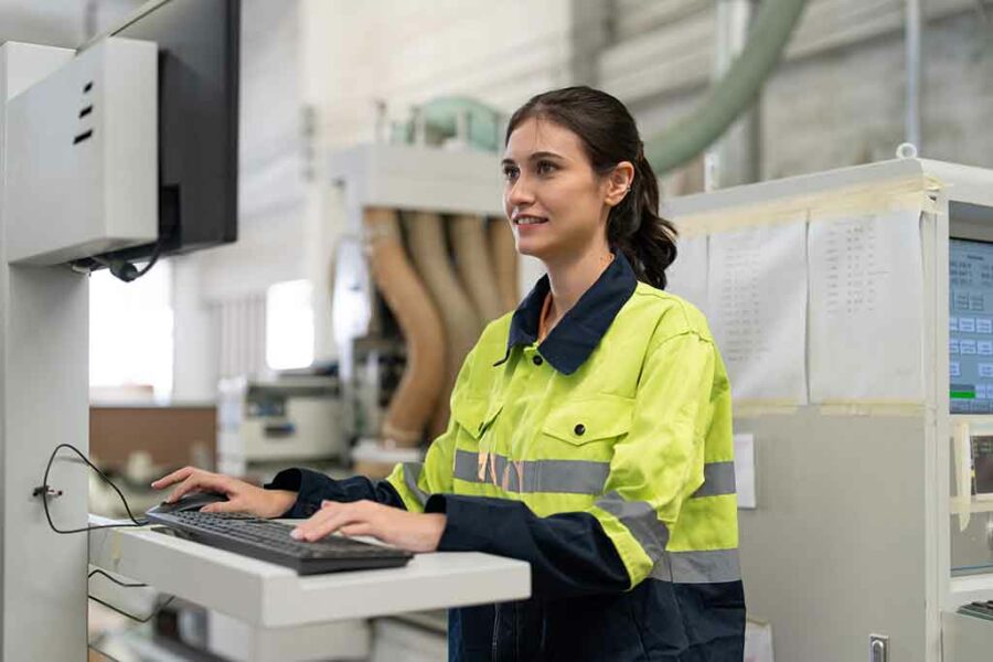 Une femme ingénieure utilisant un ordinateur pour faire fonctionner une machine à commande numérique