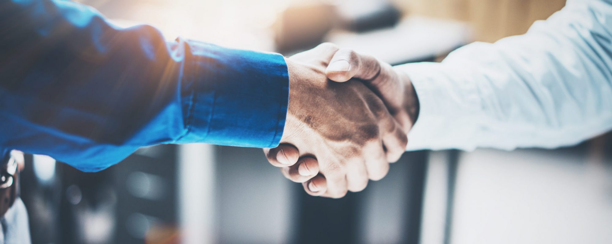 Close up view of business partnership handshake concept.Photo of two businessman handshaking process.Successful deal after great meeting.Horizontal, blurred background