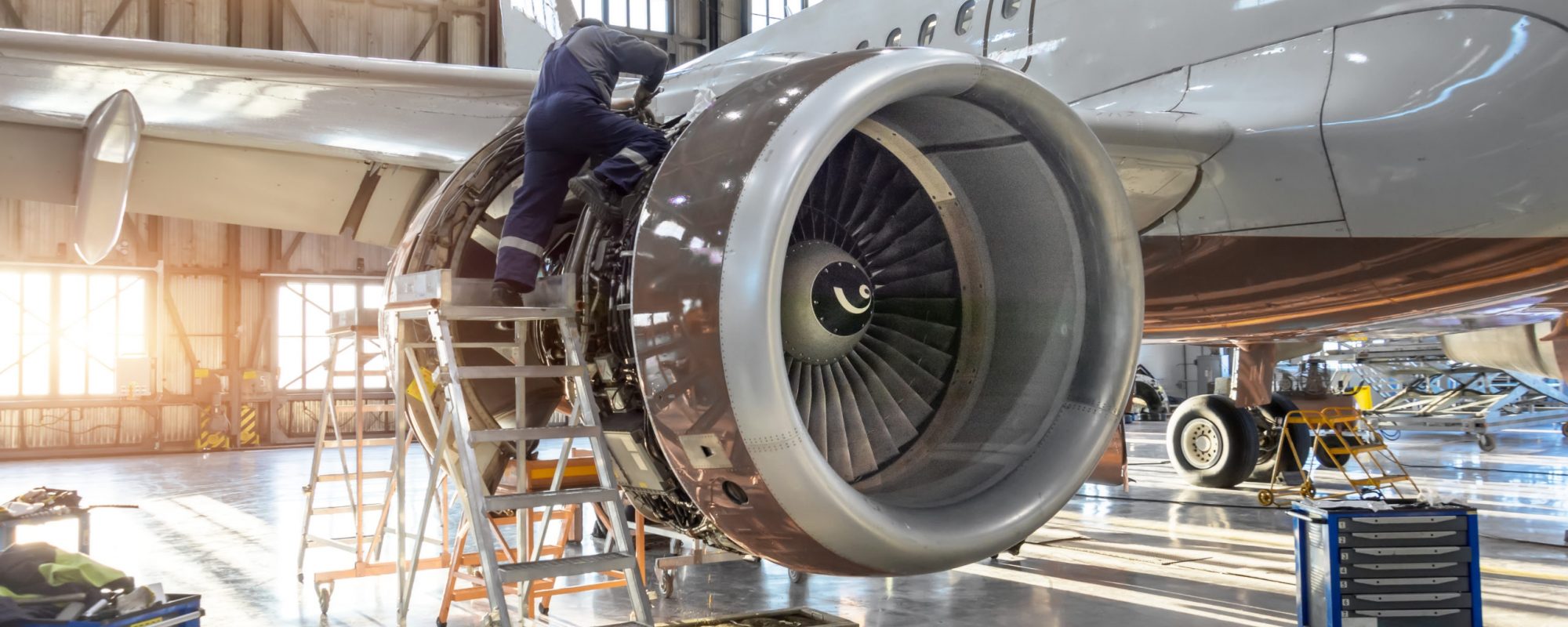 Mechanic specialist repairs the maintenance of engine of a passenger aircraft in a hangar.