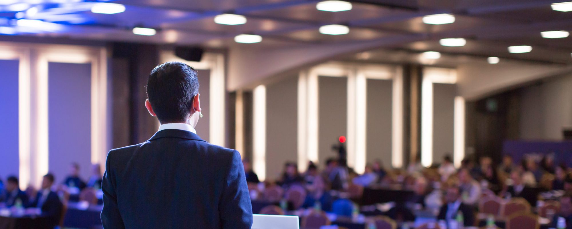 Speaker giving a talk at a corporate business conference. Audien