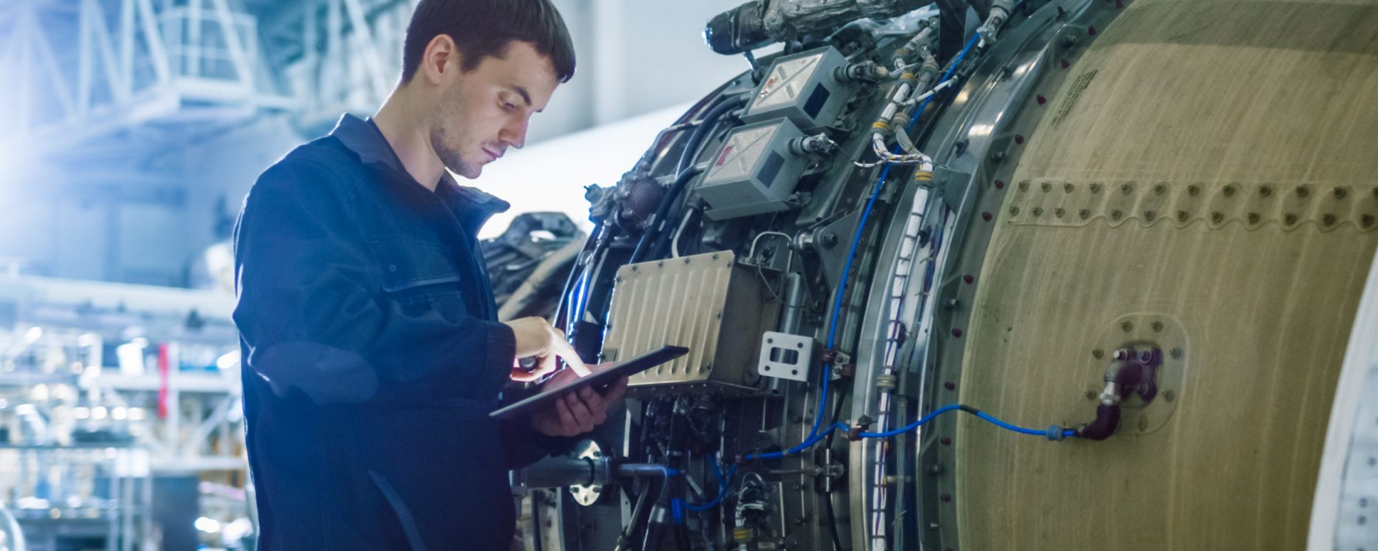 Aircraft Maintenance Mechanic Inspecting and Working on Airplane Jet Engine in Hangar