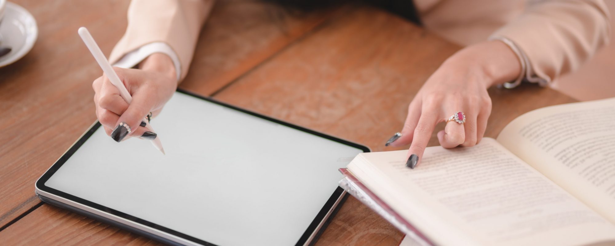 Close-up view of young businesswoman working on her project with blank screen digital tablet in comfortable workplace