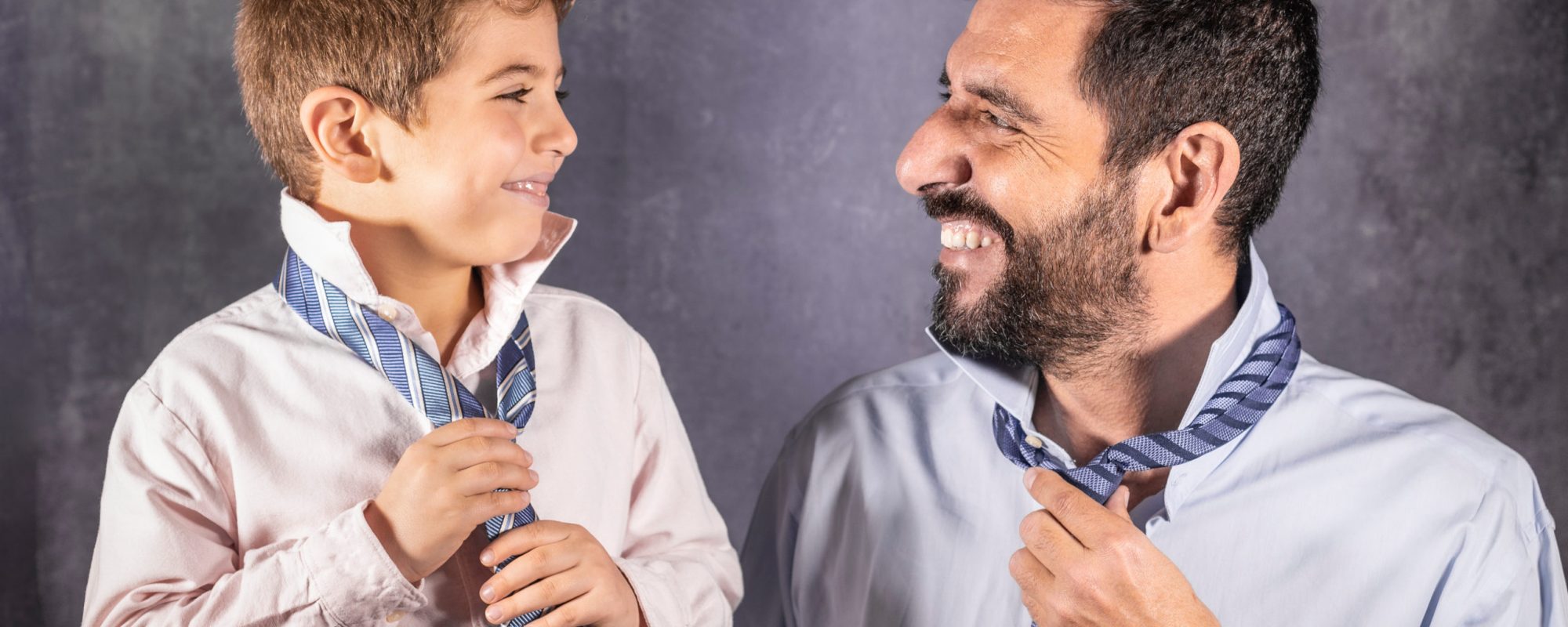 Father and son putting on a tie. Fathers Day concept.